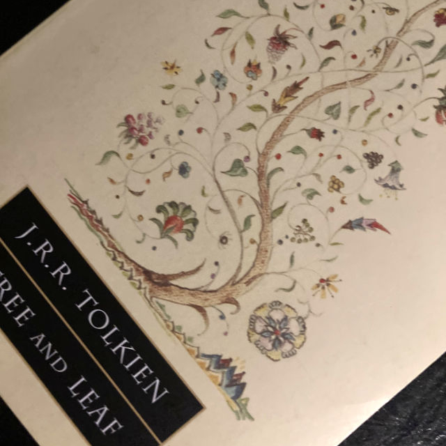 A photo taken diagonally of the softcover book, the 2011 edition of *Tree and Leaf* by J.R.R. Tolkien