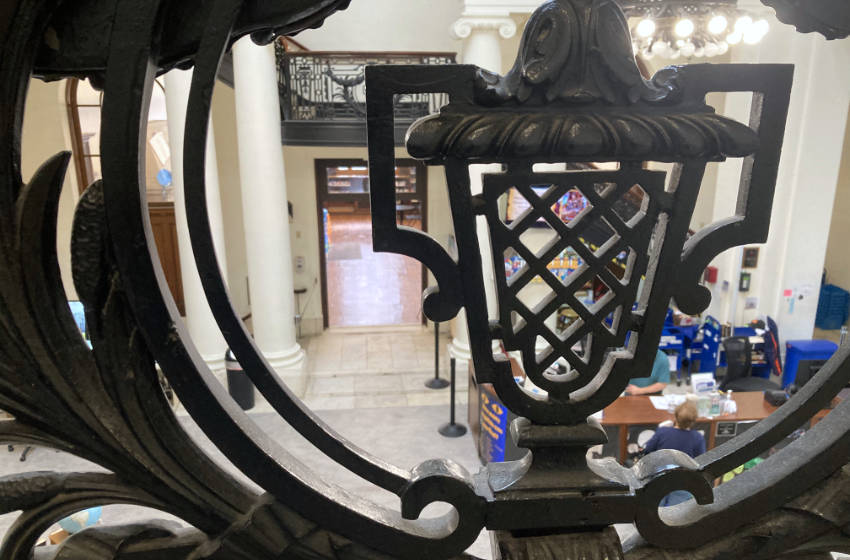 Interior of Utica Public Library, overlooking the lobby through the wrought ironwork staircase